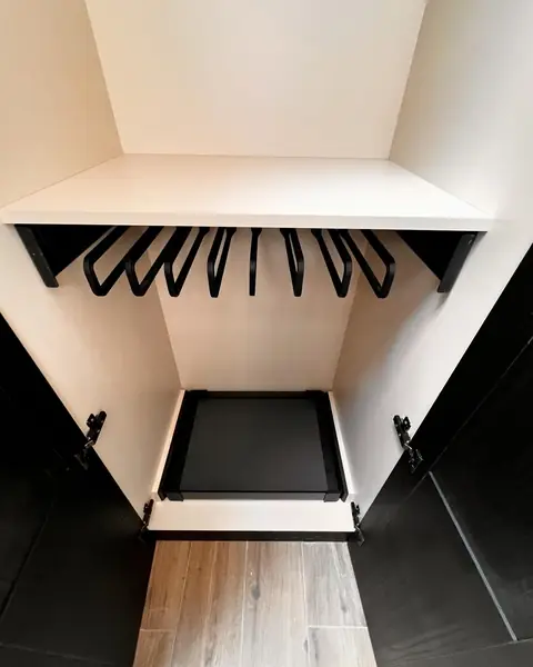Intérieur d'un dressing sur mesure : penderie, porte-pantalons et rangement bas.